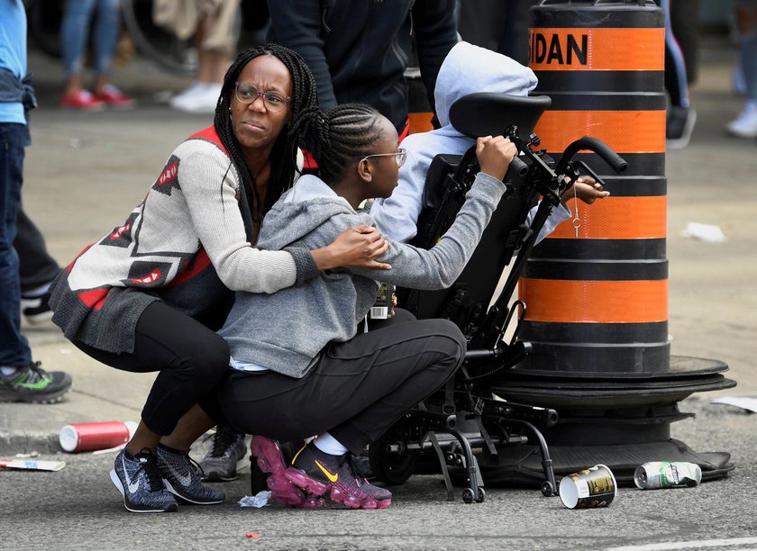 A crowd of people and police attend to the injured following a shooting during a victory celebration