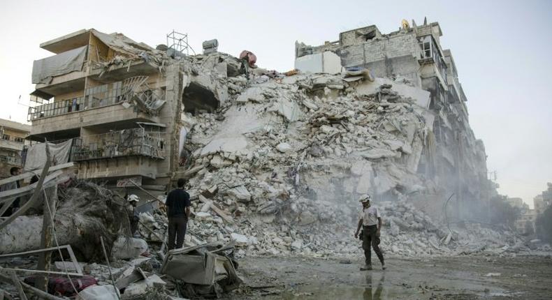 Members of the Syrian Civil Defence search for victims amid the rubble of a destroyed building in Aleppo, on October 17, 2016