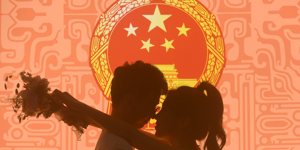 Para pozuje do zdjęcia w biurze rejestracji małżeństw w Hangzhou, prowincja Zhejiang, Chiny, 22 sierpnia 2023 r.