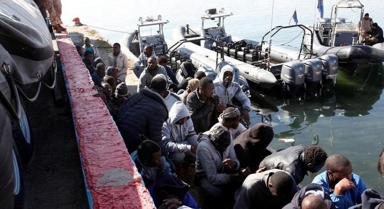 Migrants sit in a port, after being rescued at sea by Libyan coast guard, in Tripoli, Libya April 11, 2016. 