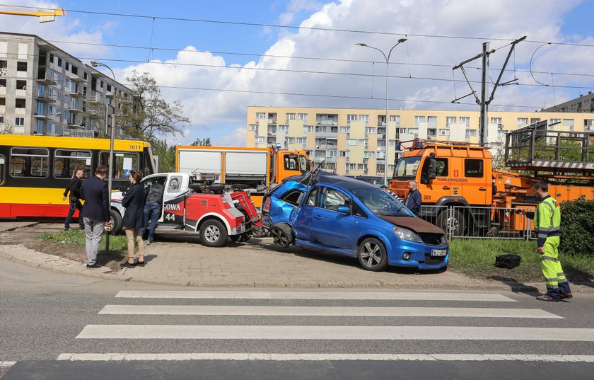 Samochód zaklinowany pomiędzy tramwajem a słupem. W środku ciężarna kobieta i dziecko