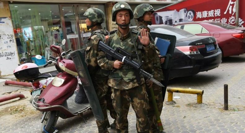 Paramilitary police stand guard outside a shopping mall in Hotan, in China's western Xinjiang region, which has seen an uptick in violence in recent years