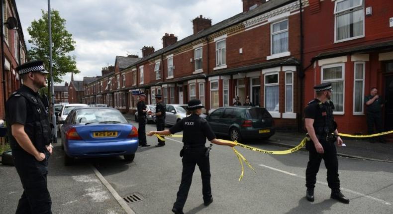 Police set a cordon outside a house in Manchester's Moss Side area on Saturday. Some local residents were evacuated and others were told to stay indoors