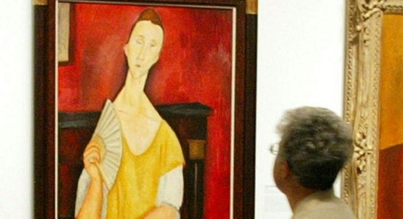 A visitor looks at the painting Woman with a Fan by Amedeo Modigliani -- one of five paintings discovered missing on May 20, 2010 at the Paris Musee d'Art Moderne (Modern Art Museum)