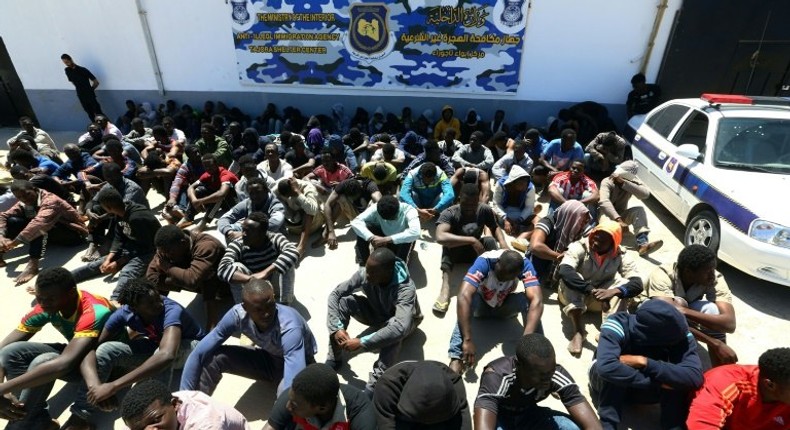 Illegal migrants, who were found by Libyan security forces while waiting in a depot in Tripoli's eastern suburb of Tajoura prior to being smuggled to Europe, gather at the new Tajoura detention centre in the Libyan capital on May 9, 2017