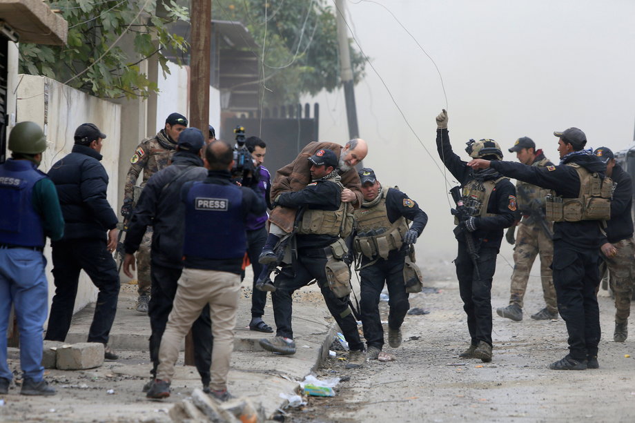 Iraqi Special Operations Forces (ISOF) carry an injured man from clashes with ISIS militants in Mosul, November 30, 2016