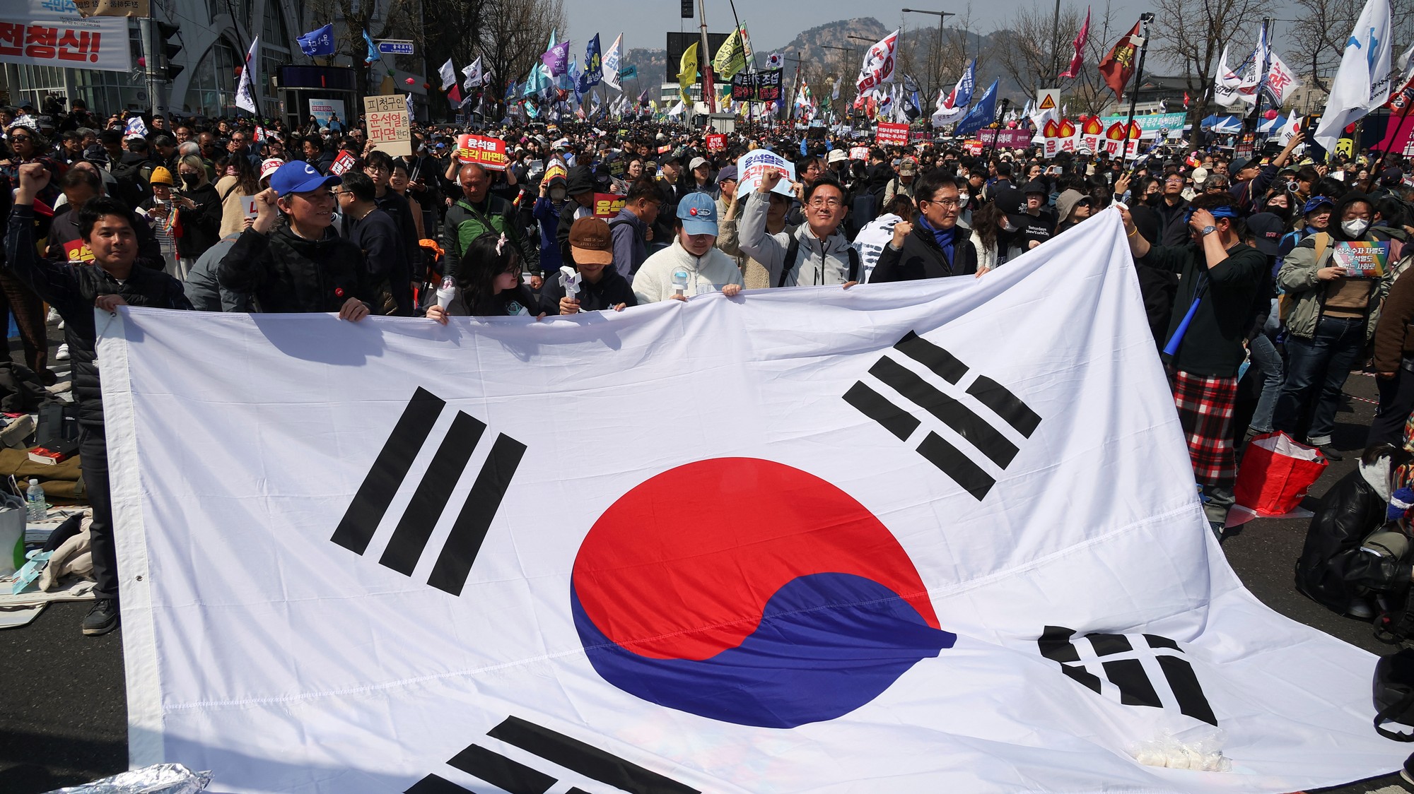 Ľudia oslavujú po prijatí obžaloby prezidenta Juna Suka Jula neďaleko Ústavného súdu v Soule v Južnej Kórei, REUTERS/Kim Hong-ji