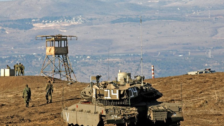 Israeli troops equipped with armoured vehicles survey neighbouring Syria from the Golan Heights, a strategic plateau Israel seized from Syria in the Six-Day War of 1967