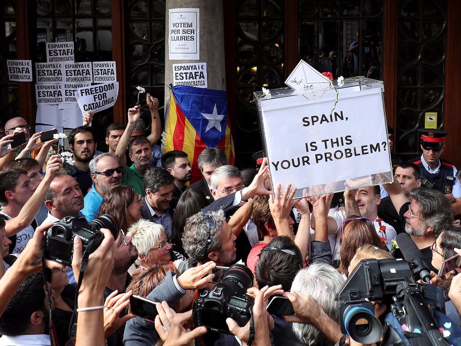 Pro-Catalonian independence protesters lift up a ballot box in Barcelona in September.