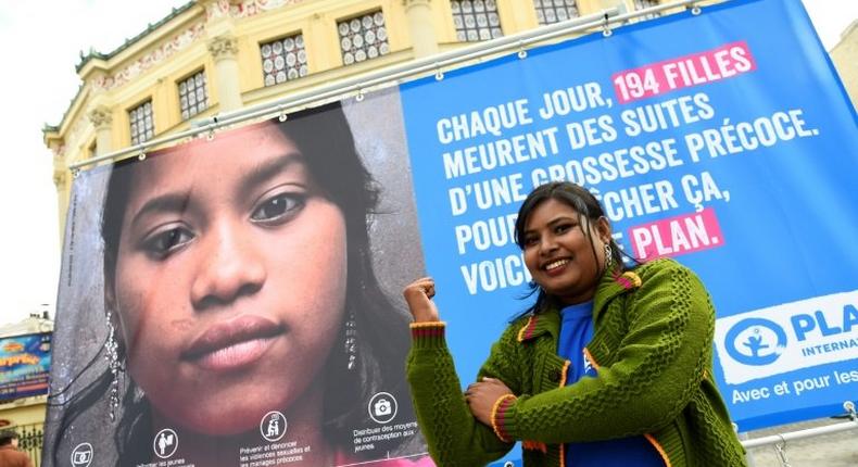 Radha Rani Sarker, who escaped forced marriage at the age of 14 in Bangladesh, pictured in front of NGO Plan International's campaign poster in Paris on the eve of the UN International Day of the Girl Child, on October 10, 2016