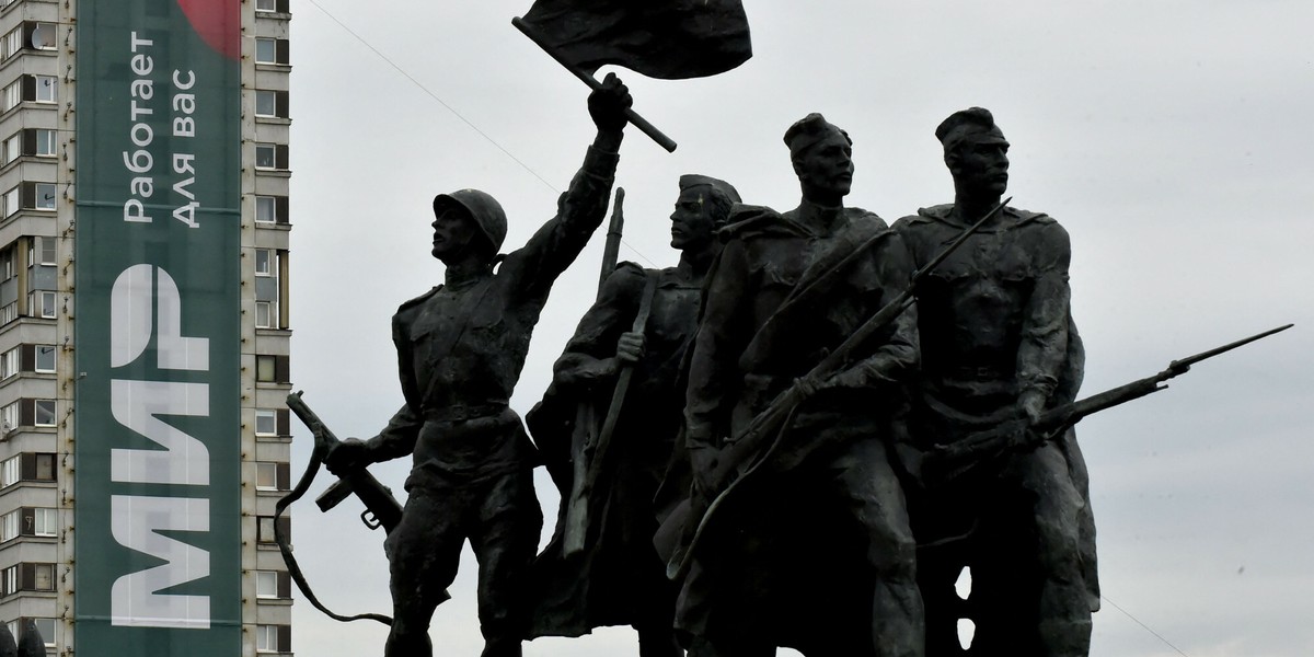 Baner rosyjskiego narodowego systemu płatności kartą Mir na boku budynku mieszkalnego za pomnikiem z czasów II wojny światowej w Sankt Petersburgu.