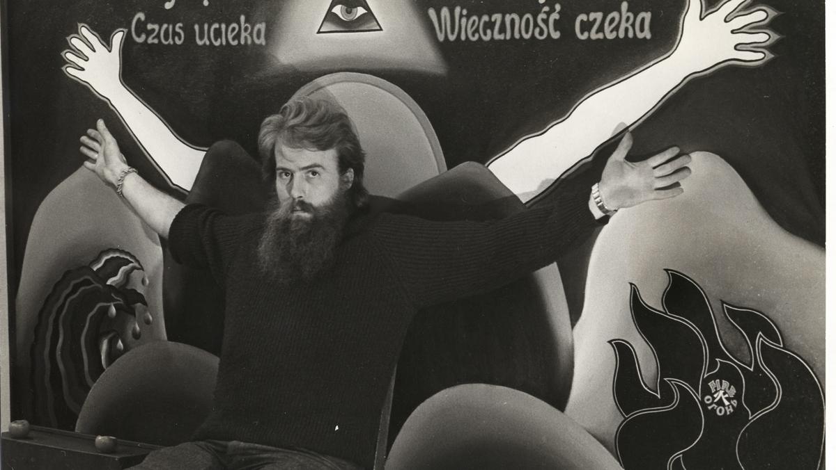 Andrzej Urbanowicz na tle swojego obrazu „Czas ucieka, początek lat 70