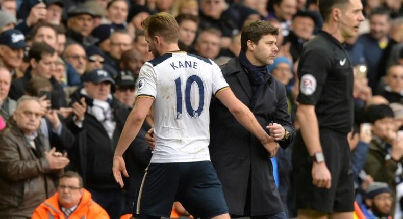 Tottenham Hotspur's Harry Kane (L) is greeted by team manager Mauricio Pochettino as he leaves the pitch substituted during their English Premier League match against Stoke City, at White Hart Lane in London, on February 26, 2017