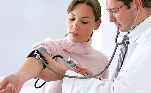 Lekarz sprawdza kobiecie ciśnienie krwi