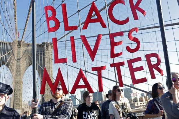 Demonstrators hold a "Black Lives Matter" banner while participating during the March for Racial Justice on the Brooklyn Bridge in the Brooklyn borough of New York, U.S., on Sunday, Oct. 1, 2017. The March for Racial Justice is a multi-community movement organized to protest against systemic racism and promote civil rights for all. Photographer: Yana Paskova/Bloomberg