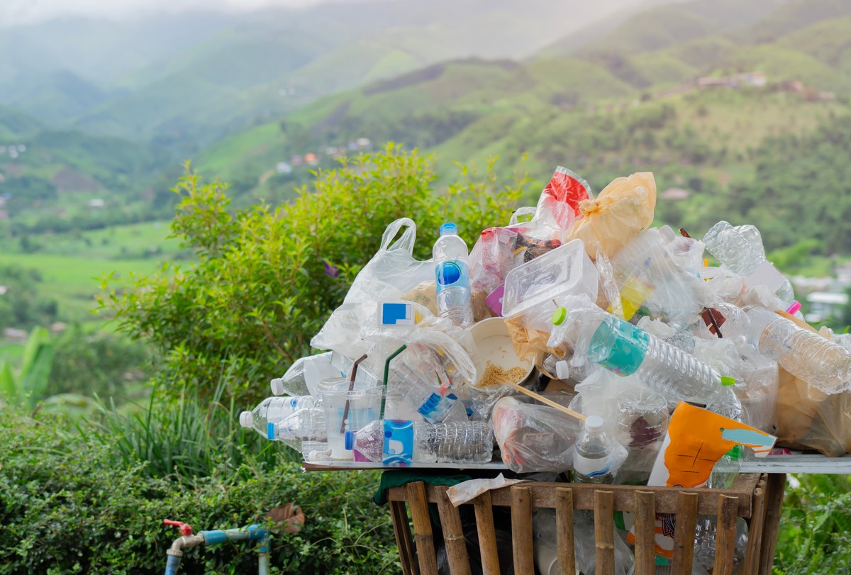 góra plastikowych butelek w koszu na tle przyrody