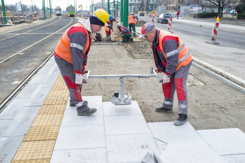 Robotnicy robią chodnik na przystanku