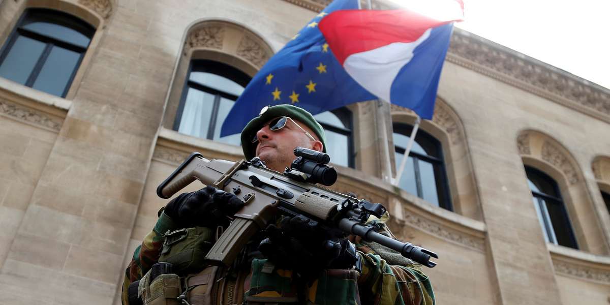 A Belgian soldier in front of the French embassy in Brussels on Friday as French and European Union flags fluttered at half-staff to honor the victims of the Bastille Day truck attack in Nice.