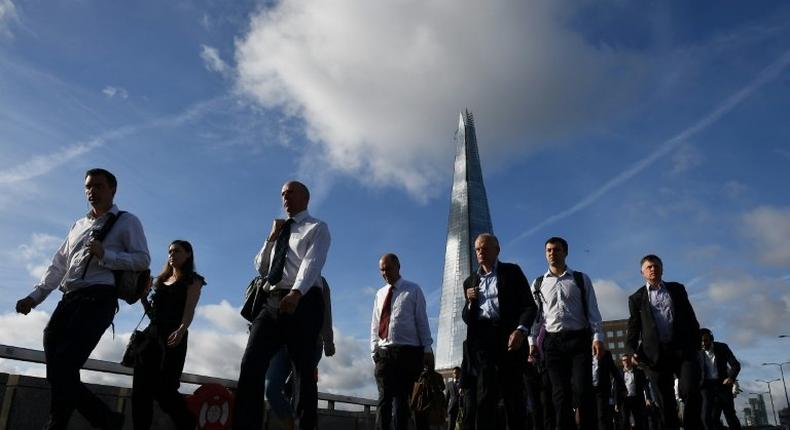 Commuters walk across London Bridge, backdropped by The Shard, in London on June 5, 2017