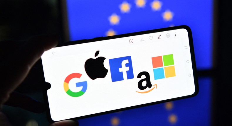 Google, Apple, Facebook, Amazon, and Microsoft logos displayed in front of an EU flag.JUSTIN TALLIS/AFP via Getty Images