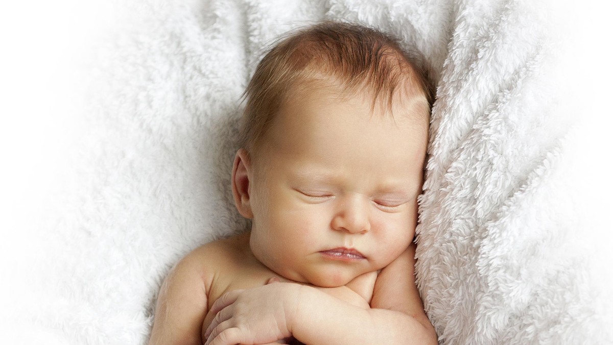 newborn baby sleeping on a white blanket