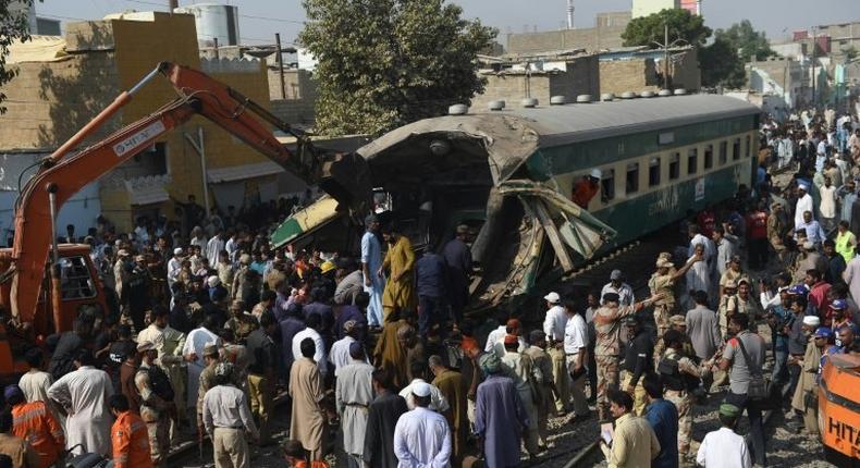 Bystanders watch the rescue work at the site of a collision between two trains in Karachi, southern Pakistan on November 3, 2016