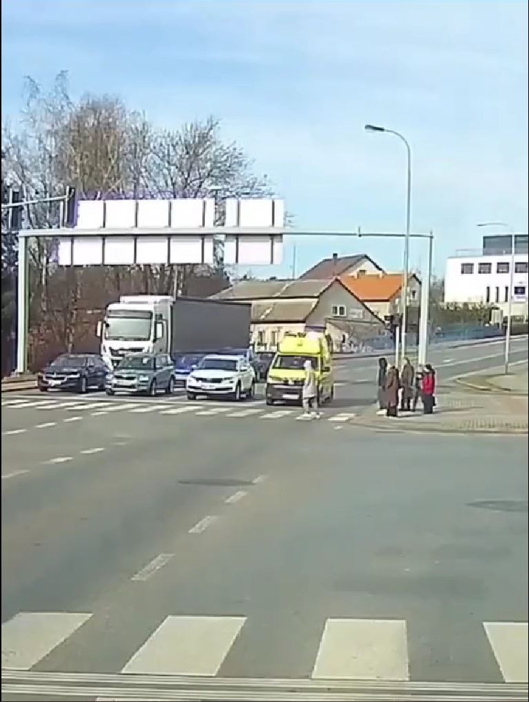 Pred sanitku vbehli chodci. 