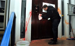 Poseł Nitras czyścił oblane farbą drzwi biura PiS. Brudziński dziękuje za ten gest