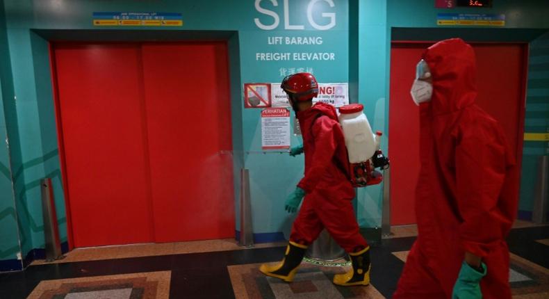 Indonesian fire fighters spray disinfectant at a business center on the last day of the lockdown amid the COVID-19 coronavirus pandemic in Jakarta