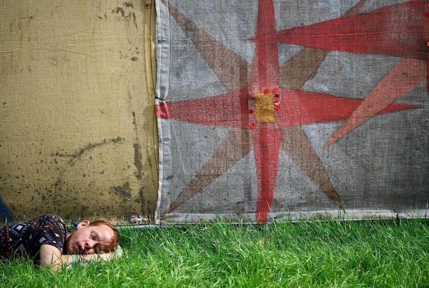 A reveller sleeps at Worthy Farm in Somerset during the Glastonbury Festival
