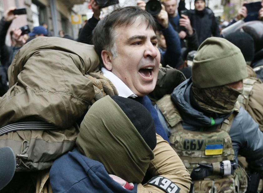 Supporters of Georgian former President Mikheil Saakashvili break a window a police car carrying Saa