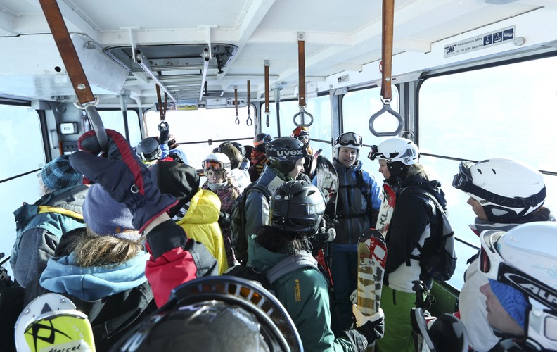 Davos jest popularnym kurortem narciarskim w szwajcarskich Alpach. Na zdjęciu: Davos - narciarze w kolejce linowej.