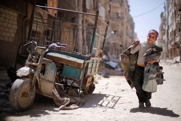 A boy walks along a damaged street at the city of Douma in Damascus