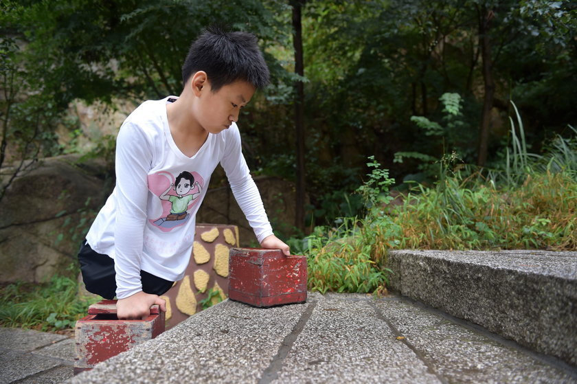 Gao Zhiyu wspina się na górę przy pomocy drewnianych klocków