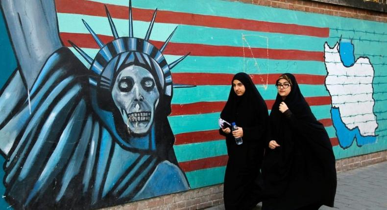 Iranian women walk past the former US embassy in Tehran on November 3, 2016, during a demonstration marking the start of its 1979 siege