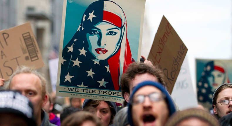 Demonstrators march on the street near a security checkpoint inaugural entrance, Friday, Jan. 20, 2017 in Washington, ahead of President-elect Donald Trump's inauguration.