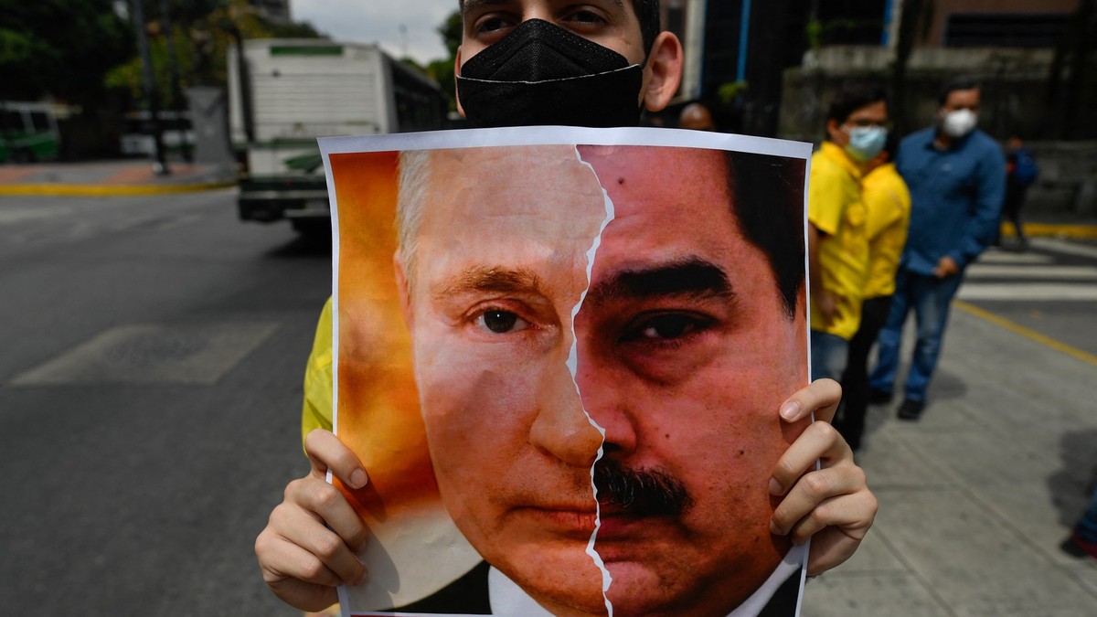 Aktivista opozicione stranke Primero Justicija drži transparent sa likom ruskog predsednika Vladimira Putina i predsednika Venecuele Nikolasa Madura tokom protesta protiv ruske invazije na Ukrajinu, u Karakasu 4. marta. 2022.