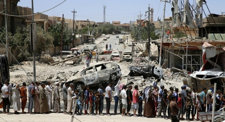 Iraqis stand in line to receive food aid in west Mosul's Zanjili neighbourhood as Iraqi forces battle to retake the city from Islamic State group jihadists