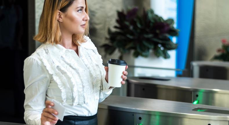 Coffee badging refers to workers who swipe in at the office solely to meet return-to-office requirements but don't do much work there, instead leaving quickly to finish their work elsewhere.kotijelly / Getty Images