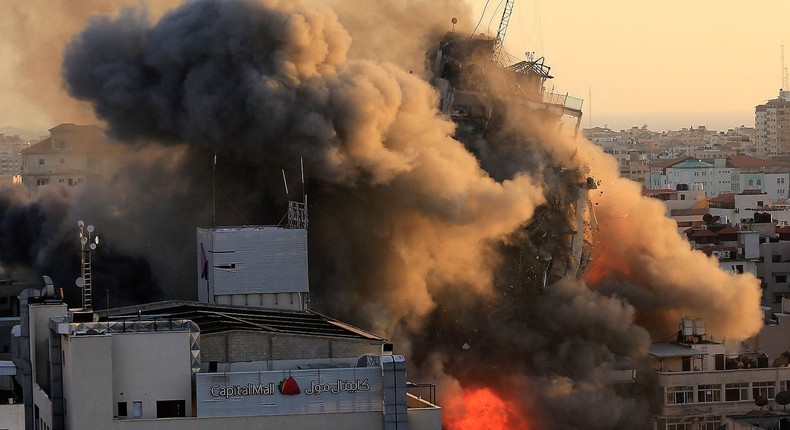 Heavy smoke and fire surround Al-Sharouk tower as it collapses during an Israeli air strike, in Gaza City on May 12, 2021.
