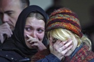 Women mourn during commemoration ceremony at the Dubrovka Theatre in Moscow