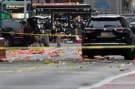 Evidence markers are seen on street around security officials near site of explosion in New York