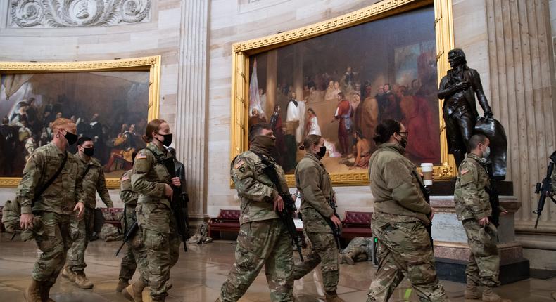 Members of the National Guard walk through the Rotunda of the US Capitol in Washington, DC, January 13, 2021, ahead of an expected House vote impeaching US President Donald Trump.
