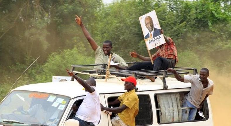 A supporter of Amama Mbabazi, former Ugandan prime minister and presidential candidate for The Democratic Alliance (TDA), holds a poster of him atop a mini bus during a campaign rally ahead of the February 18 presidential election, in Lyantonde town, Uganda January 25, 2016.  REUTERS/James Akena