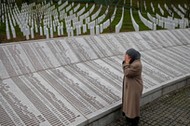 Bida Smajlovic, prays near the Memorial plaque with names of killed in Srebrenica massacre before wa