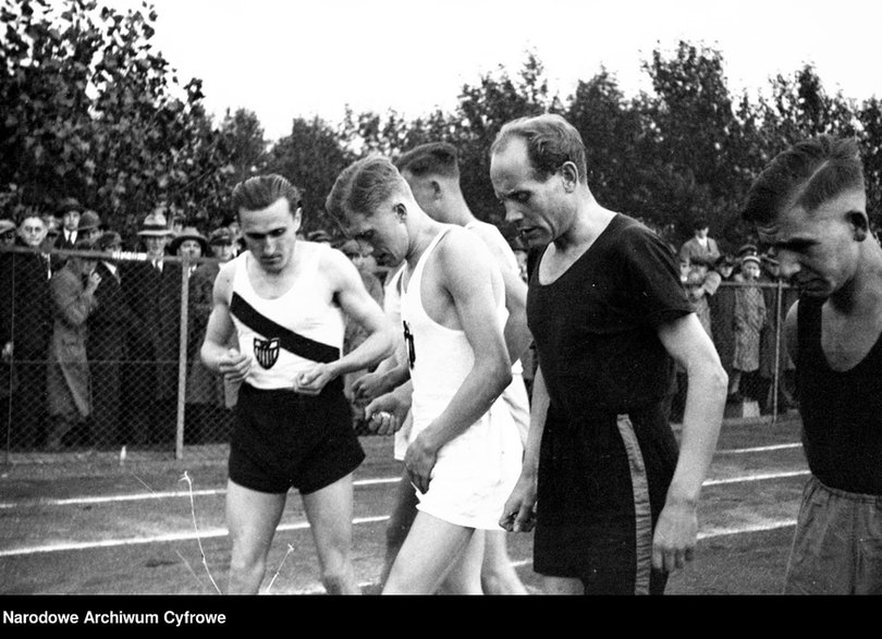 Lekkoatleci przed biegiem. Widoczni od lewej: Janusz Kusociński, Stanisław Petkiewicz, Paavo Nurmi. Źródło: Narodowe Archiwum Cyfrowe.