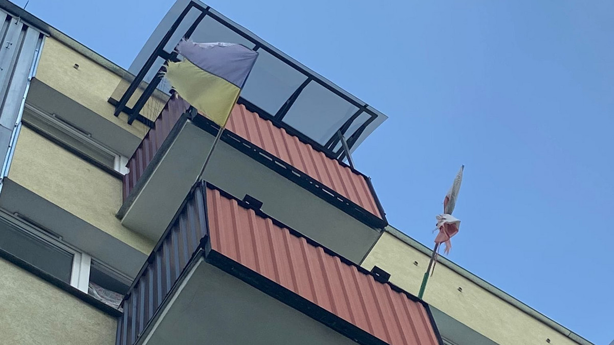 Brudne i podarte flagi na balkonie. Ktoś zadzwonił po straż miejską