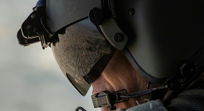 A partial view of the Iraqi capital is reflected in the visor of a US army helicopter crew member as he looks out of a Chinook helicopter over Baghdad on January 9, 2019