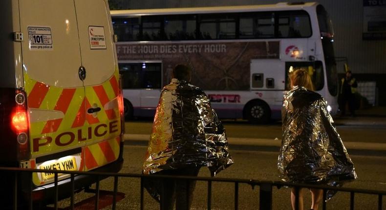 Concert goers wait to be picked up after a suspected terror attack during a pop concert by Ariana Grande in the northern English city of Manchester