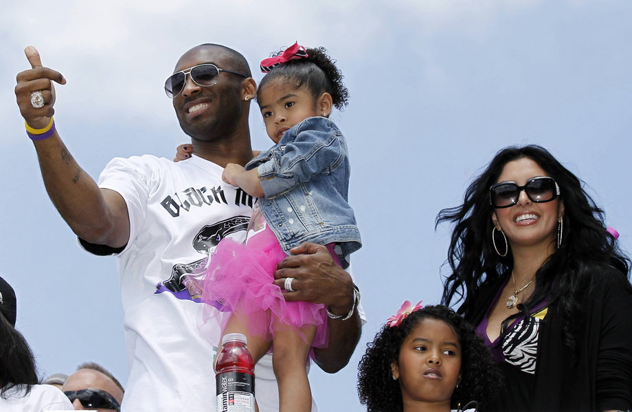 During the parade celebrating the Lakers' 2010 NBA Championship, Bryant holds his daughter, Gianna, while his wife, Vanessa, and other daughter, Natalia, stand by his side.